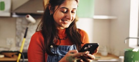 Woman doing renovation and checking a website on her phone